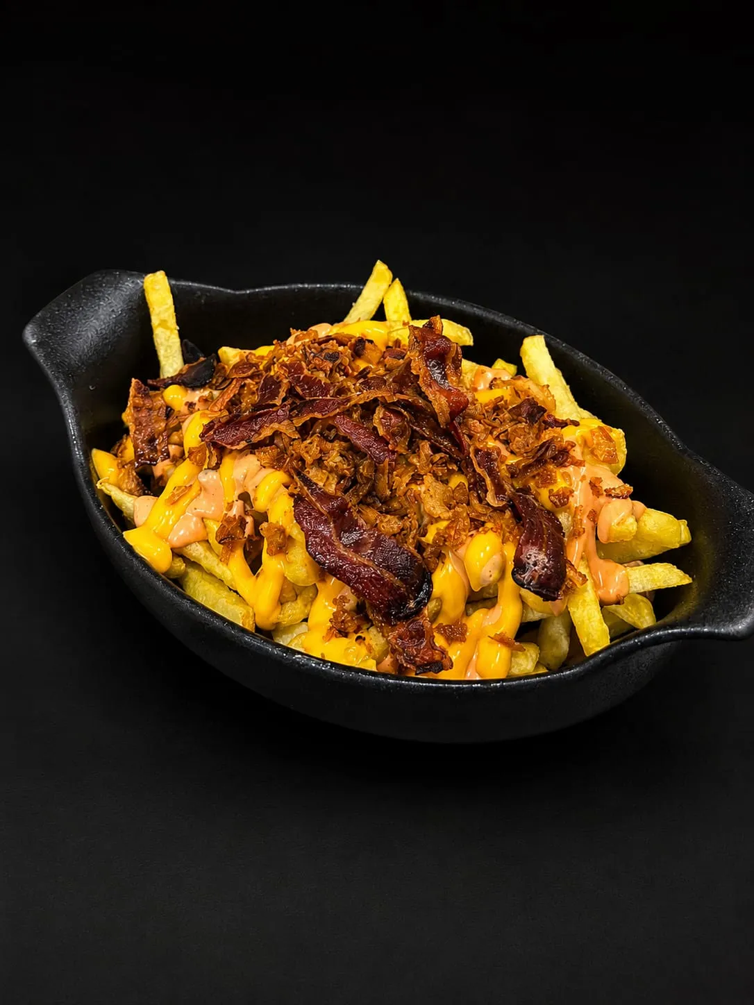 Loaded fries with melted cheese, bacon and fried onion